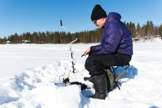 Guided ice fishing excursion Guided ice fishing on a frozen lake