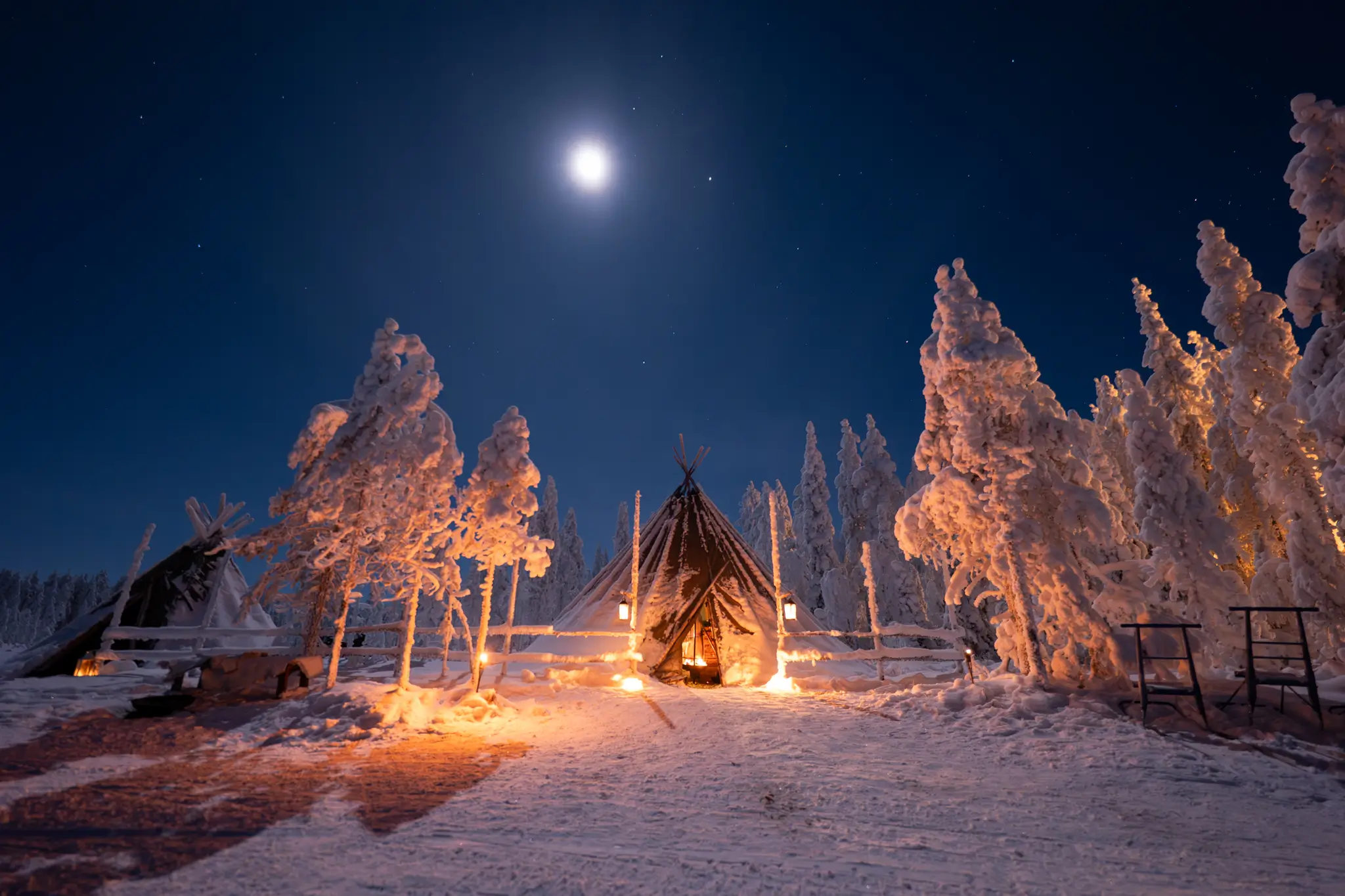 Luminen leiripaikka Ranuan metsän keskellä kuutamoisena talviyönä
